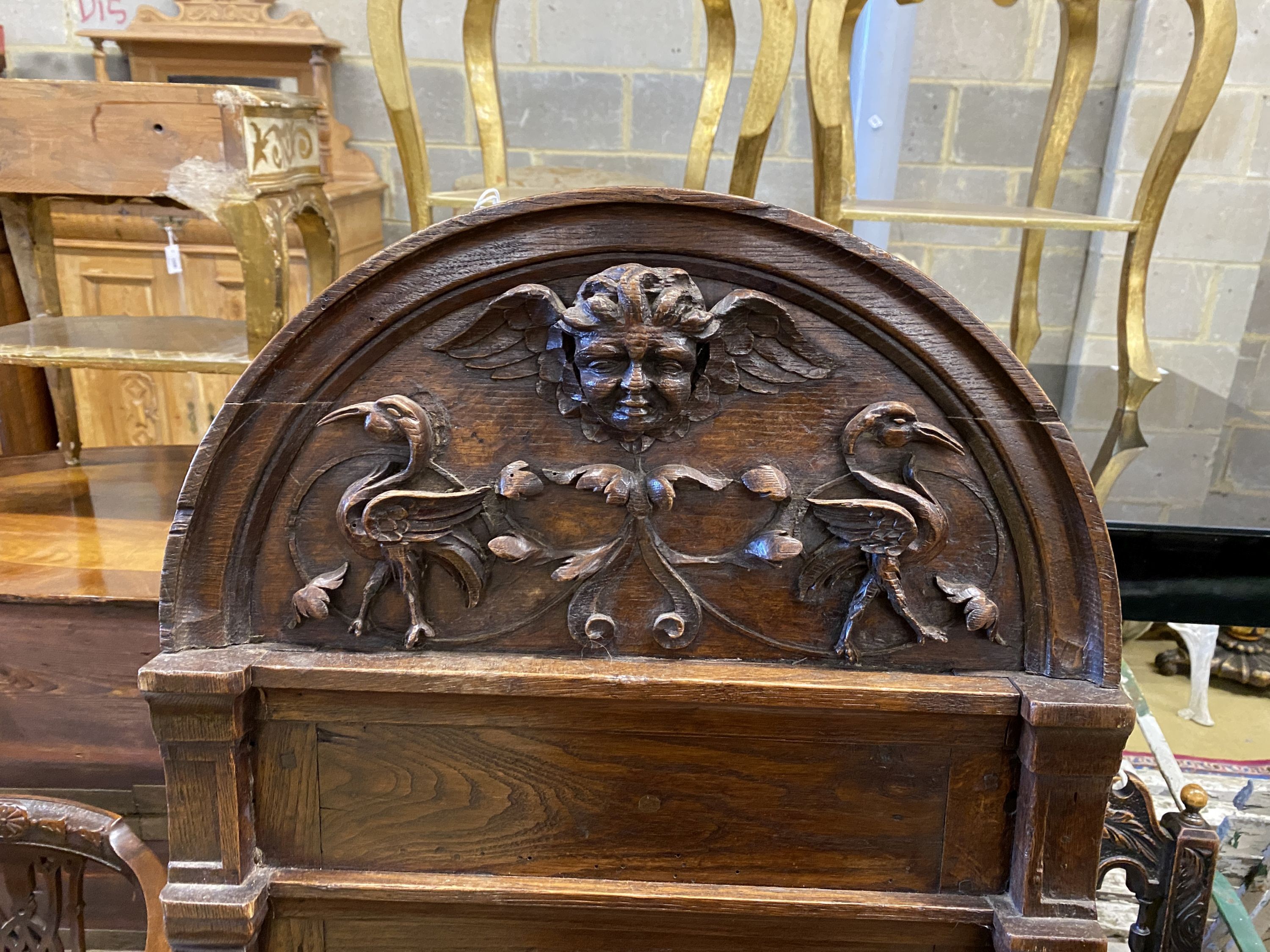 A 19th century carved oak plaque with cherub head pediment, width 50cm, height 145cm